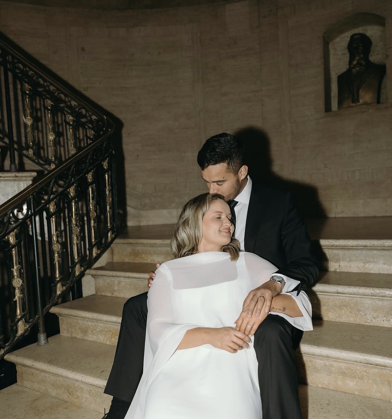 Matheus kissing Layza's forehead on the candlelit staircase