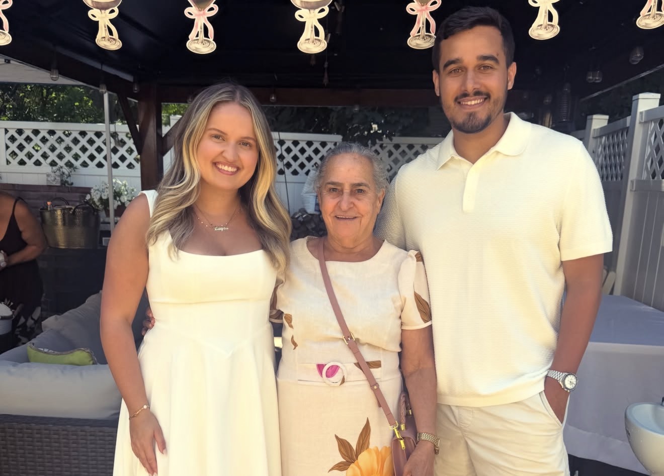 The couple with grandmother under the lights of the garden party