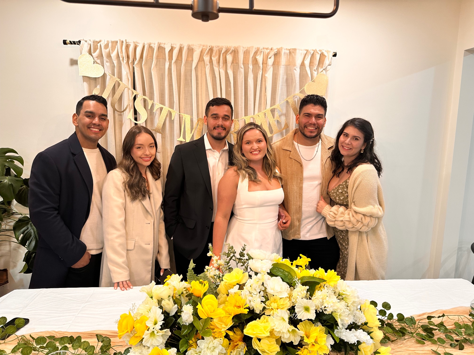 The newlyweds with friends under the Just Married banner