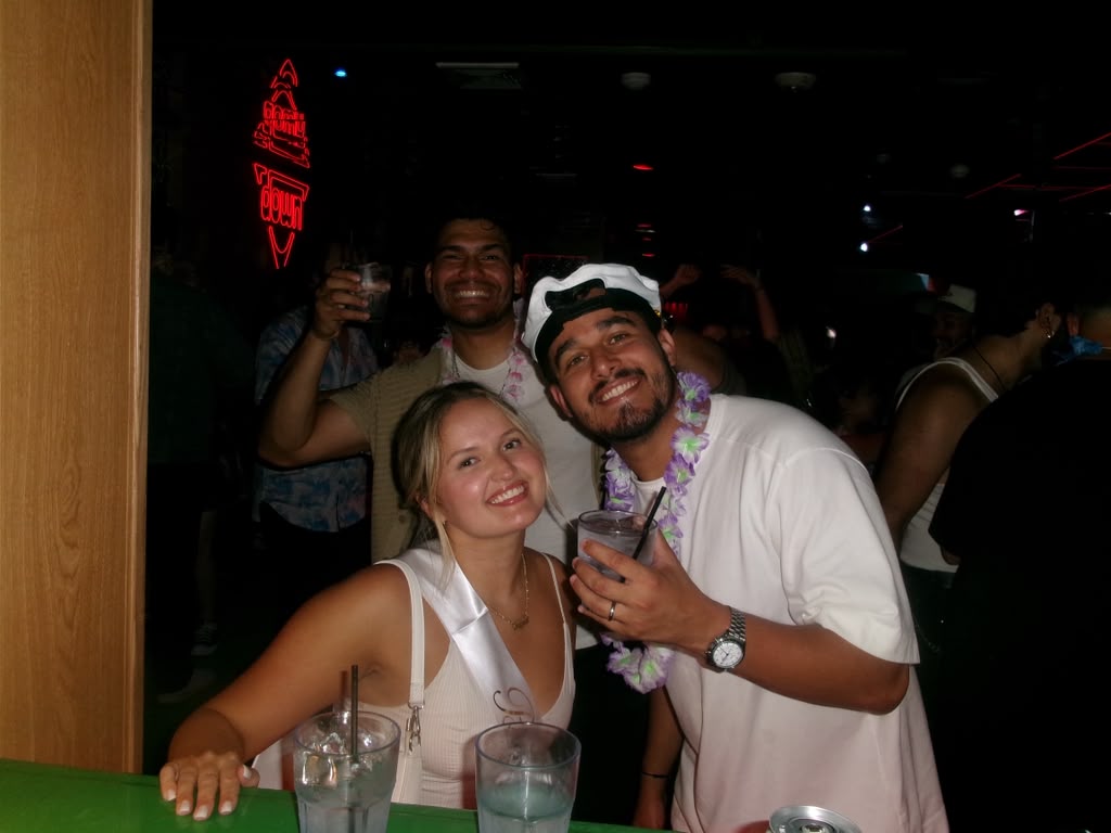 Matheus and Layza raising a toast with friends at the bar