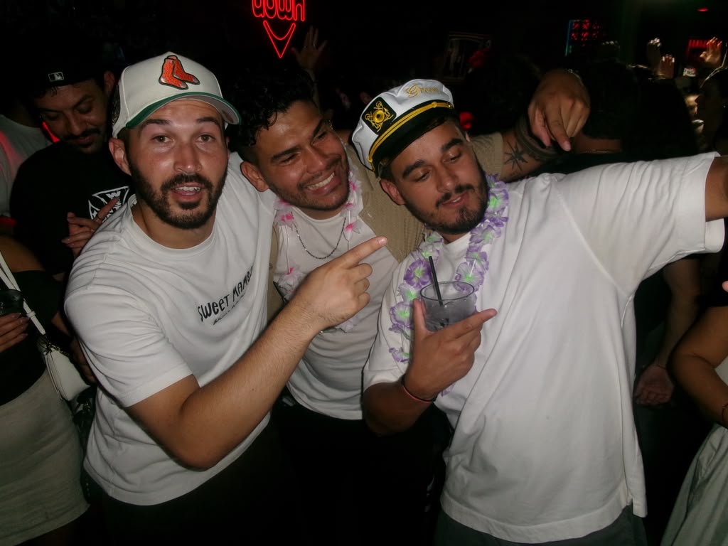 The groom and his friends in leis and captain's hats on the dance floor